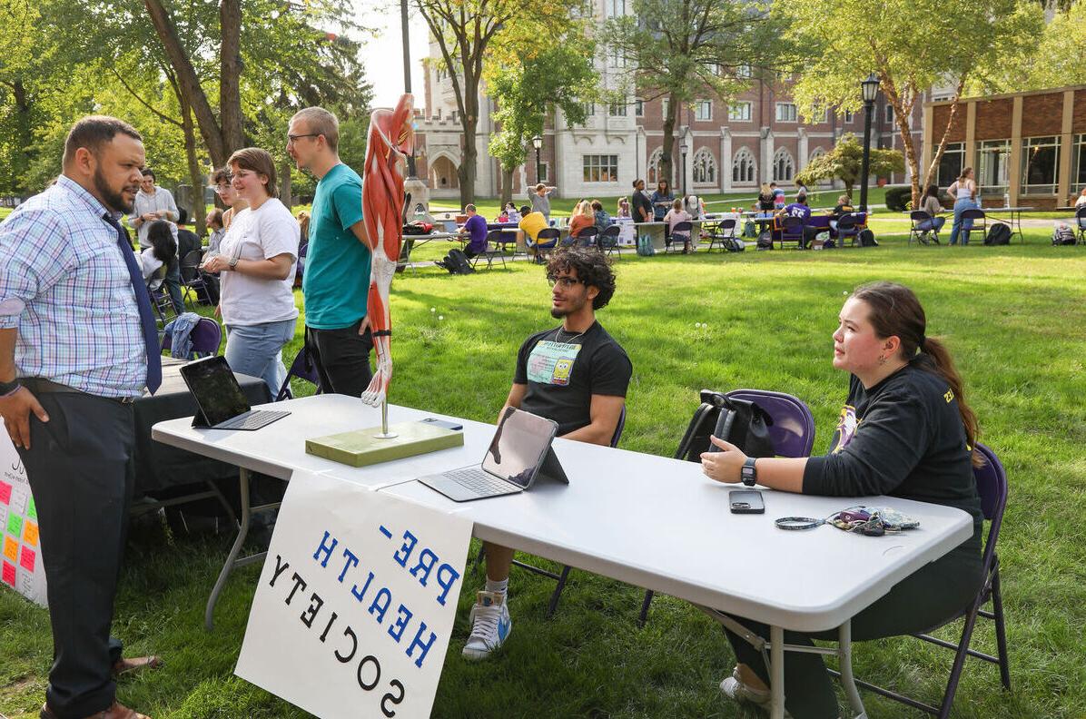 Members of the Pre-Health Society speak with a visitor to their table during the Engagement Fair